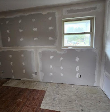 Drywall repair and finishing in progress around a window