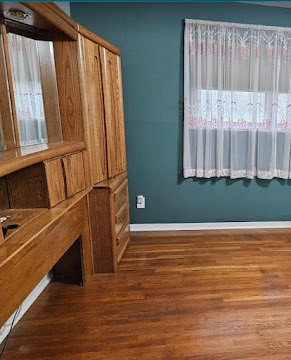 Refinished room with restored hardwood floor and painted accent wall